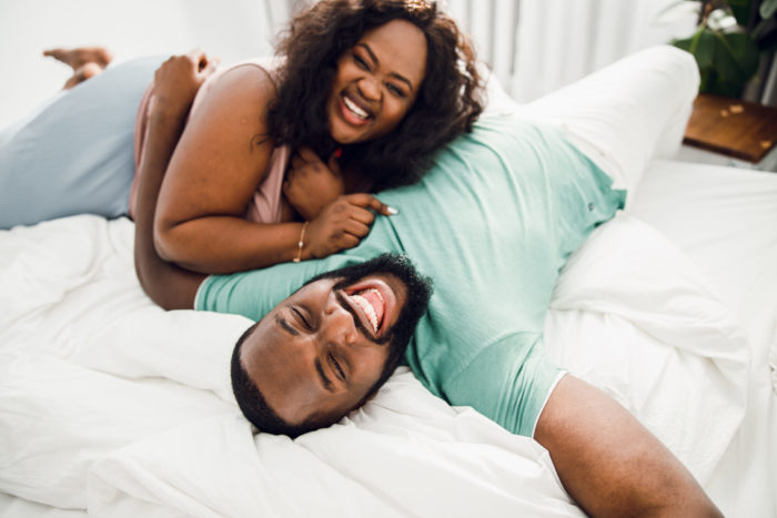 Laughing couple on the white bed stock photo