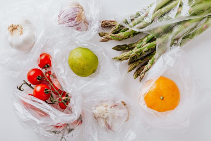 fruit and vegetables in plastic bags on a white table