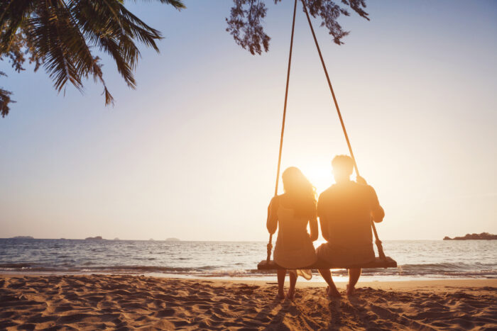 Honeymoon travel, silhouete of couple in love on the beach