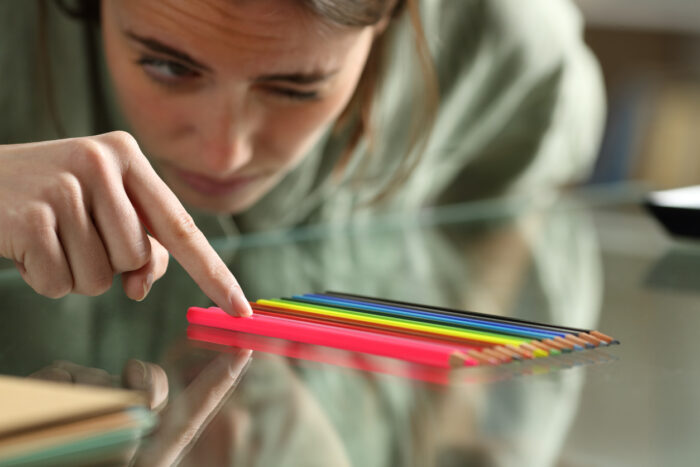 Obsessive compulsive woman aligning up pencils on a table