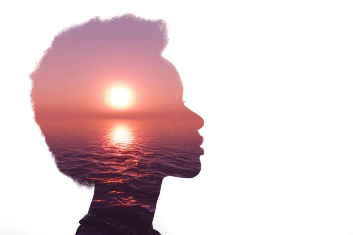 Sunrise and sea image inside the silhouette of a woman's head