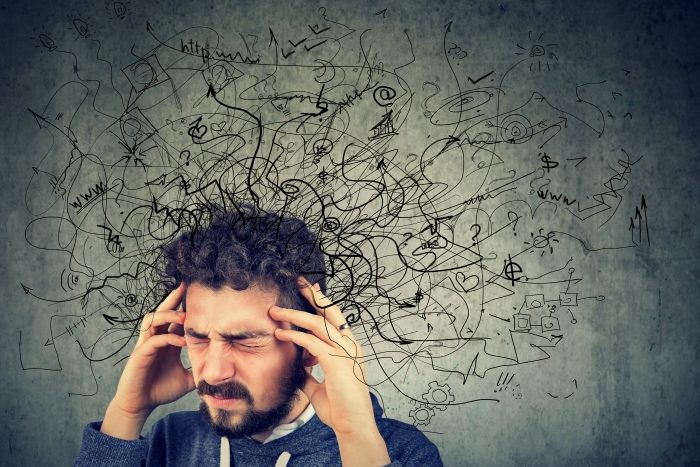 man holding head having bad thoughts thoughts are depicted with doodles