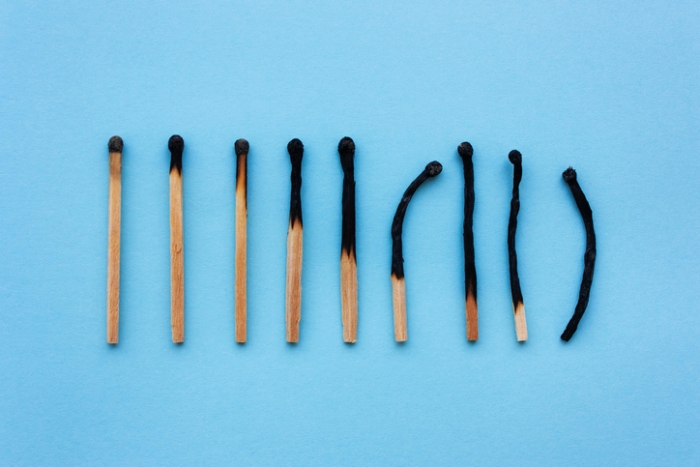 9 partially burned matches in a row on a blue background