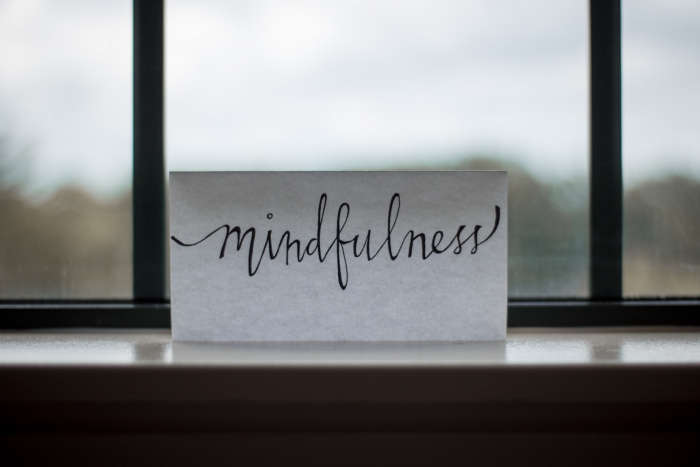 Mindfulness written in cursive on a card against the window sill