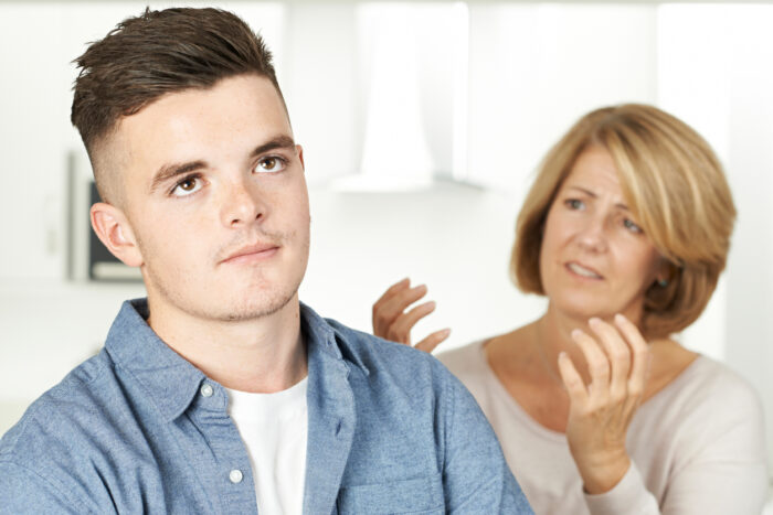 Mother arguing with teenage son, who looks annoyed