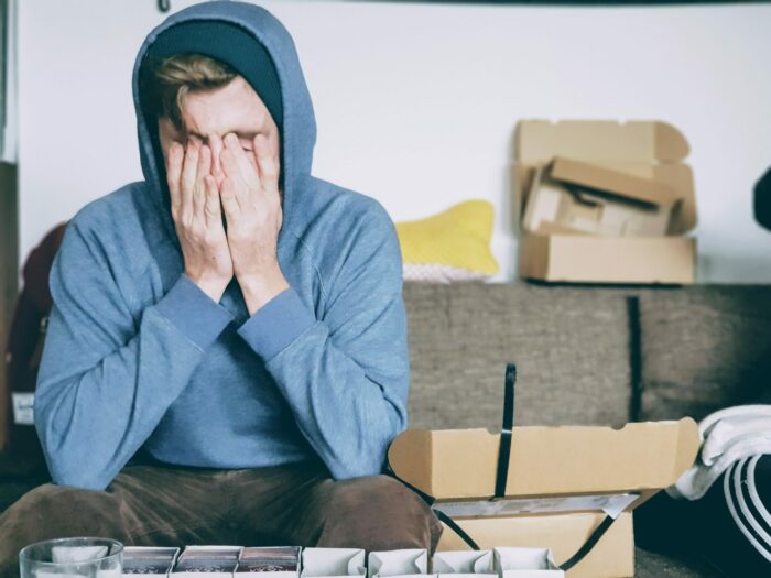 teen boy on couch with face in hands