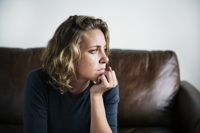 woman on couch in deep thought