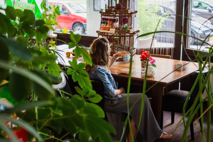 woman sitting at table surrounded by plants