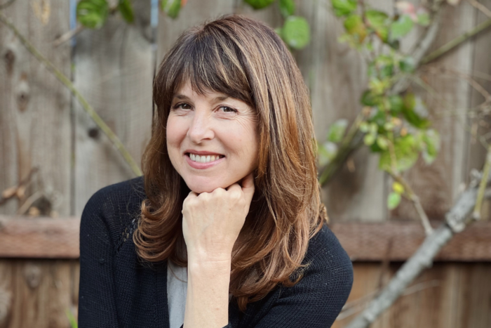 headshot of new publisher Catharine Meyers, her head is resting on her hand